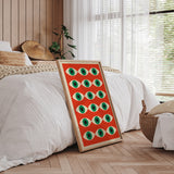 Plakat med et mønster af grønne øjne på en orange baggrund, placeret i et moderne soveværelse med træpaneler og naturligt lys.