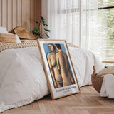 Plakat af Vilhelm Lundstrøm med to figurer, placeret op ad en seng i et stilfuldt soveværelse med træpaneler og naturligt lys.