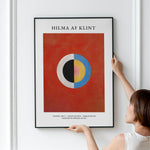 Plakat af Hilma af Klint med titlen "Svanen, Nr. 17 - Gruppe IX/SUW - Serie SUW/U", viser et abstrakt design med en cirkel i midten på en rød baggrund.