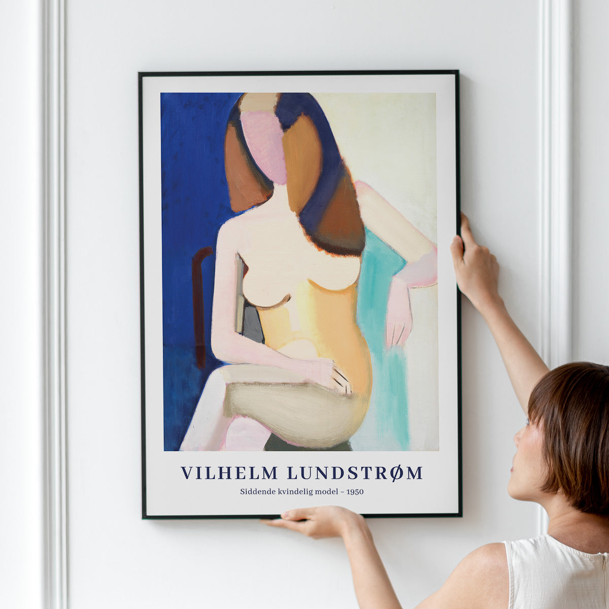 Plakat af Vilhelm Lundstrøm med titlen "Siddende kvindelig model - 1950" hænges op på en væg.