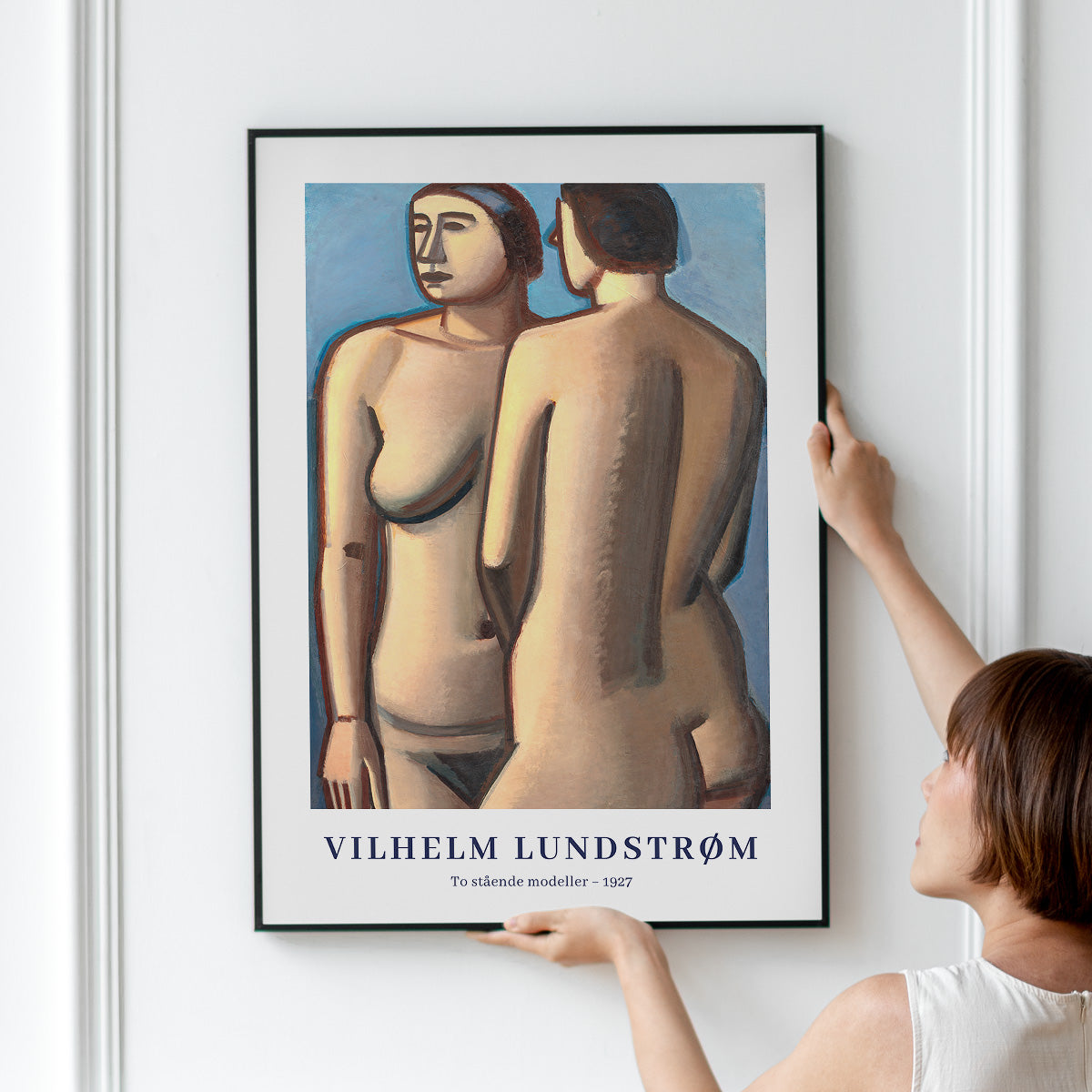 Plakat af Vilhelm Lundstrøm med titlen "To stående modeller - 1927" hænges op på en væg.