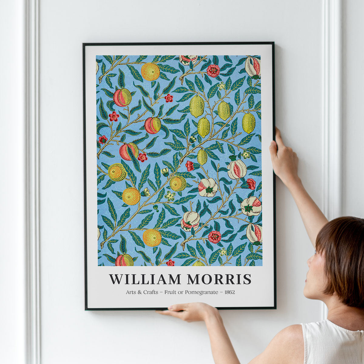 William Morris plakat med frugt- og granatæblemotiv, hængt op på en væg.