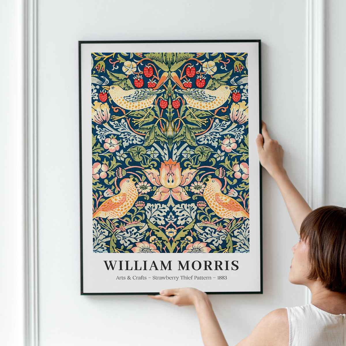 Plakat med William Morris' "Strawberry Thief Pattern" fra 1883, hængt op på en væg.