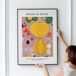 Kunstplakat Hilma af Klint Adulthood i sort ramme hænges på væg af kvinde