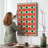 Plakat med et geometrisk øje-design i Bauhaus-stil hænges op på en væg i en stue.