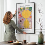 Kunstplakat Hilma af Klint Adulthood i sort ramme hænges på spisestuevæg af kvinde