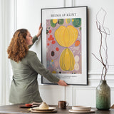 Kunstplakat Hilma af Klint Adulthood i sort ramme hænges på spisestuevæg af kvinde
