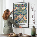 William Morris plakat med "Strawberry Thief" mønster, hængt op på en væg i en stue.