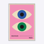 Bauhaus plakat med to stiliserede øjne i blå og grøn på lyserød baggrund, indrammet i hvid træramme.
