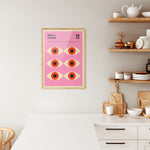 Bauhaus plakat i træramme hængende i et moderne køkken med lyse trædetaljer og hvide elementer.