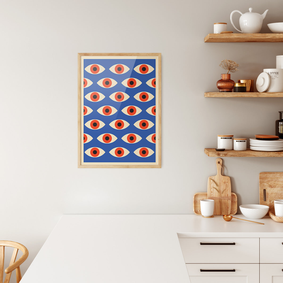Plakat i træramme i køkken med Bauhaus-design, viser et mønster af orange og blå øjne.