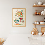 Plakat i træramme med farverige illustrationer af krabber og fisk, hængende i et moderne køkken.