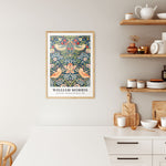 Plakat i træramme i køkken med William Morris' kunstværk "Strawberry Thief".