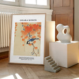 Plakat af Ohara Koson med motiv af en mejse på en gren med orange blade, placeret på et gulv ved siden af moderne skulpturer.