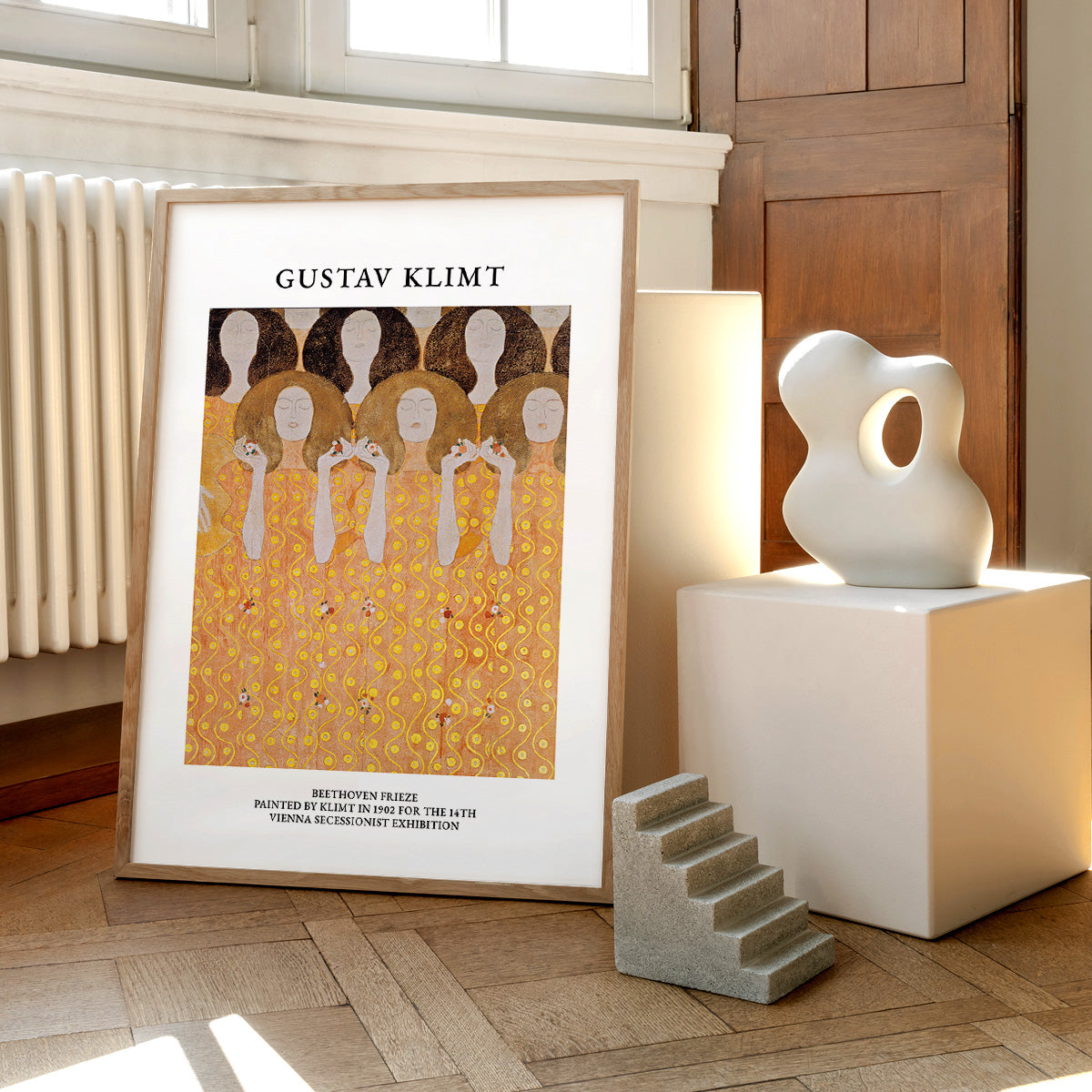 Gustav Klimt plakat med motivet "Beethoven Frieze" placeret på gulvet ved siden af moderne skulpturer.