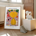 Plakat af Hilma af Klint med titlen "Adulthood" placeret på et trægulv ved siden af en skulptur og en lille trappe.