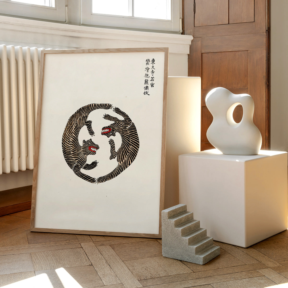 Plakat med et kunstnerisk tigerdesign af Yatsuo, placeret på et trægulv ved siden af moderne skulpturer.