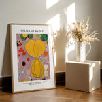 Plakat af Hilma af Klint med titlen "Adulthood" fra serien "The Ten Largest". Plakaten står på et trægulv ved siden af en vase med tørrede blomster.
