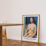 Plakat af Vilhelm Lundstrøm med titlen "Sidende kvindelig model" fra 1940, placeret på gulvet i en moderne stue ved siden af et træbord.