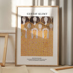 Plakat af Gustav Klimt med titlen "Beethoven Frieze" i en træramme, placeret på et gulv med skygger fra et vindue.