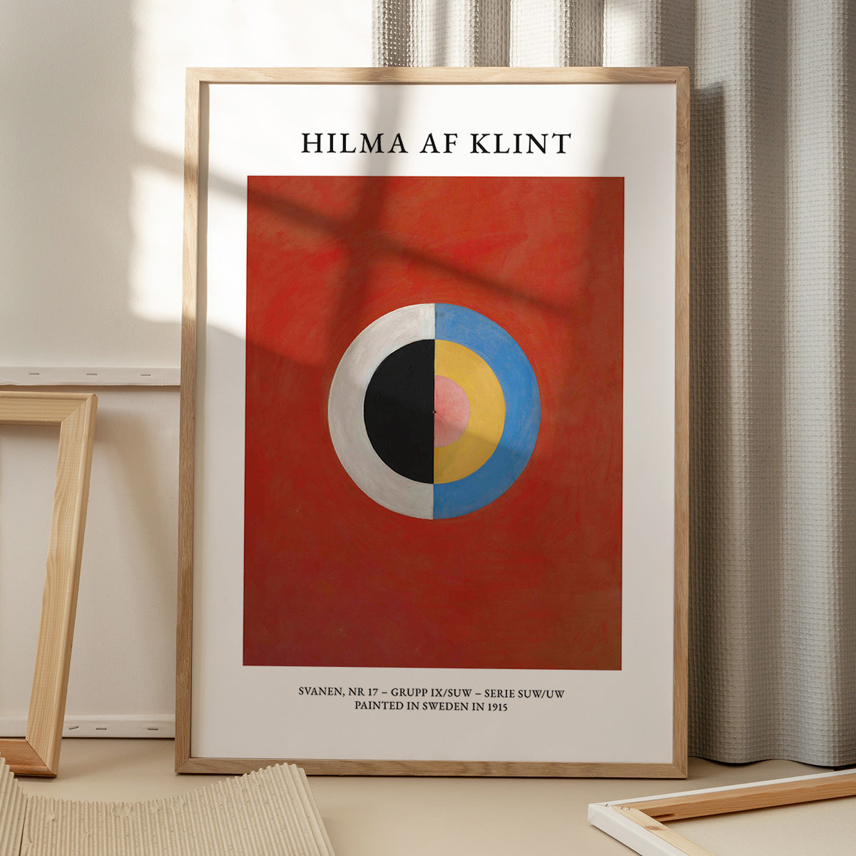 Plakat af Hilma af Klint med titlen "Svanen, Nr. 17 - Gruppe IX/SUW - Serie SUW/UW", viser et abstrakt design med cirkler i forskellige farver på en rød baggrund.
