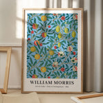 William Morris plakat med frugt- og granatæblemotiv, Arts & Crafts stil, 1862, stående på gulv med skygge fra vindue.