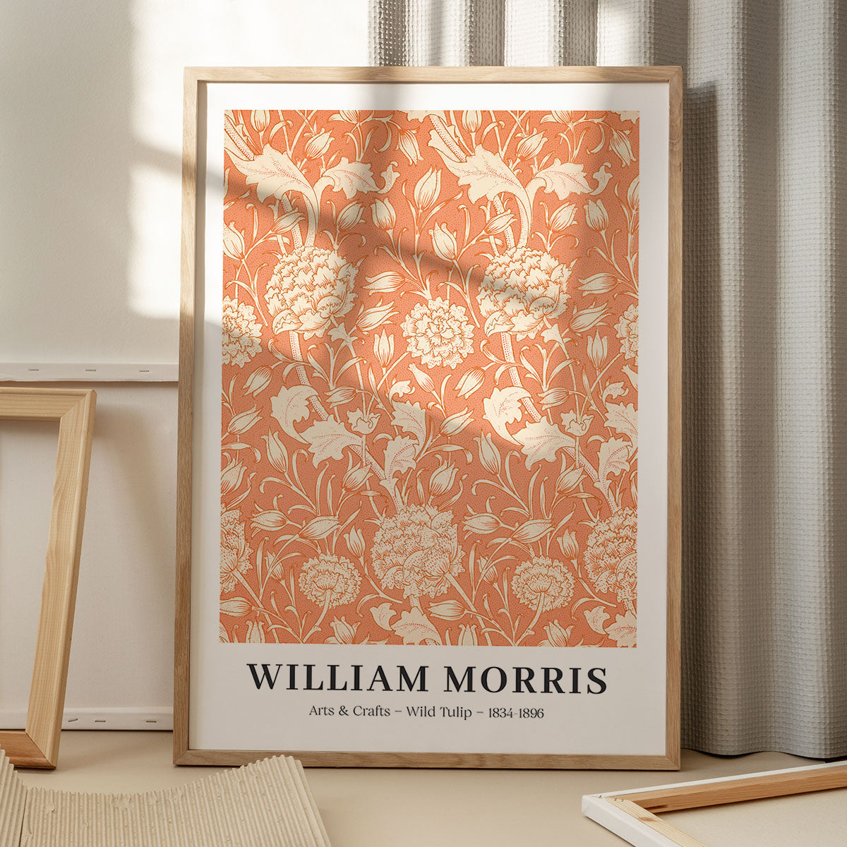 Plakat af William Morris med titlen "Arts & Crafts - Wild Tulip" i en træramme, placeret på et gulv med skygger fra et vindue.