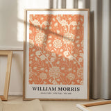 Plakat af William Morris med titlen "Arts & Crafts - Wild Tulip" i en træramme, placeret på et gulv med skygger fra et vindue.