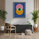 Plakat med Bauhaus-design fra 1923, hængende på en væg i en stilfuld stue med moderne møbler og planter.