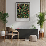 Plakat af William Morris med botanisk motiv hængende på en væg i en stilfuld stueindretning.