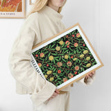William Morris plakat med botanisk motiv, holdt af en person i lys sweater.
