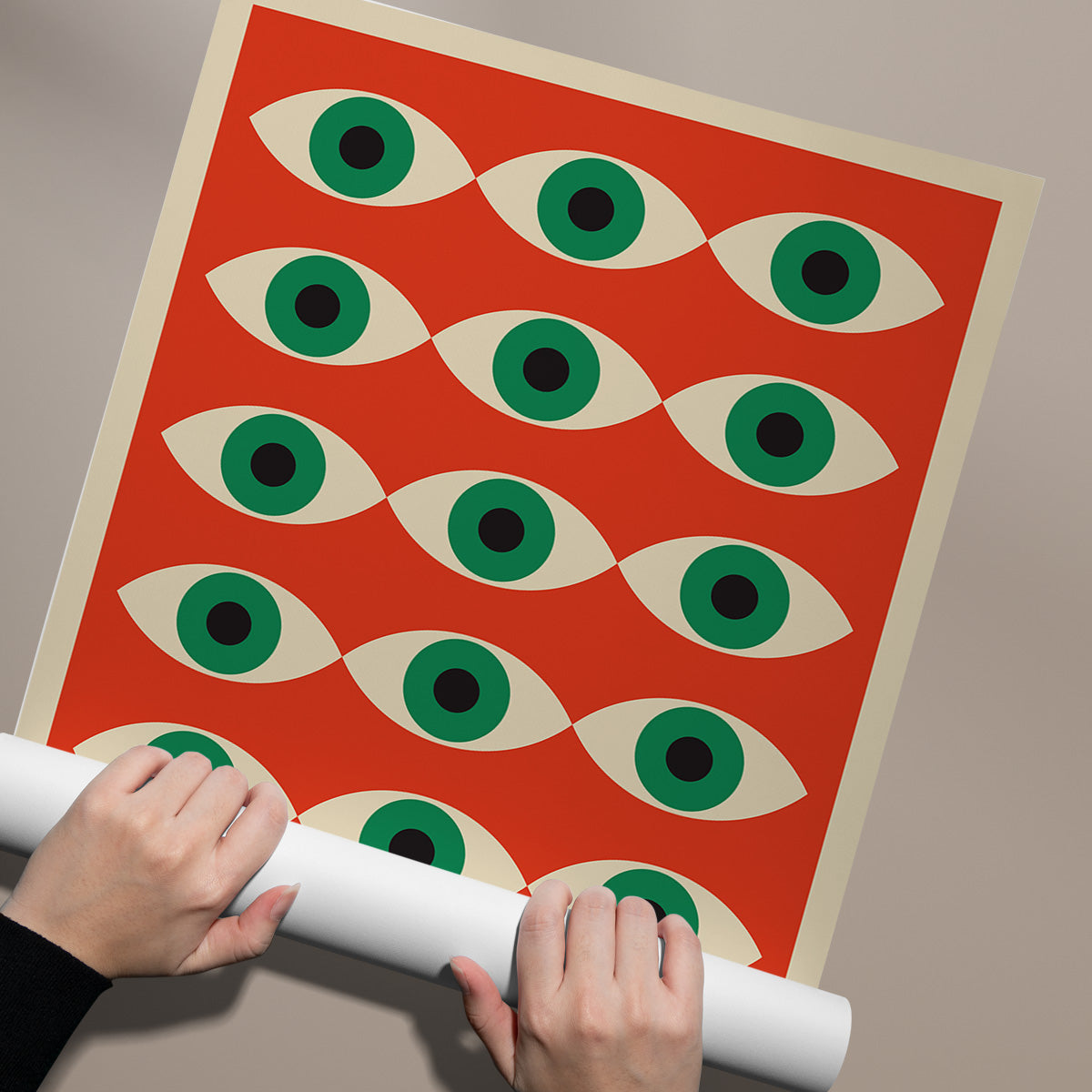 Plakat med et mønster af grønne øjne på en rød baggrund, holdt af to hænder.