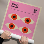 Bauhaus plakat med fire stiliserede øjne på en lyserød baggrund, årstal 1923.