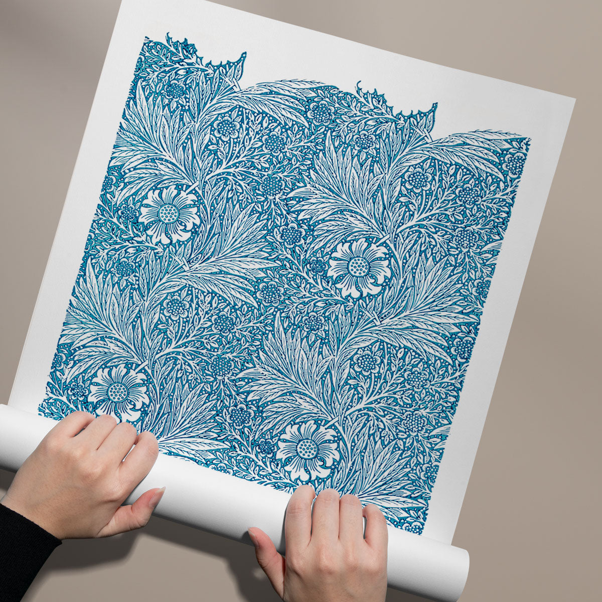 Plakat med blåt blomstermønster af William Morris, rullet ud på en beige baggrund.