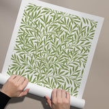 Plakat med et grønt bladmønster af William Morris, rullet ud på en neutral baggrund.