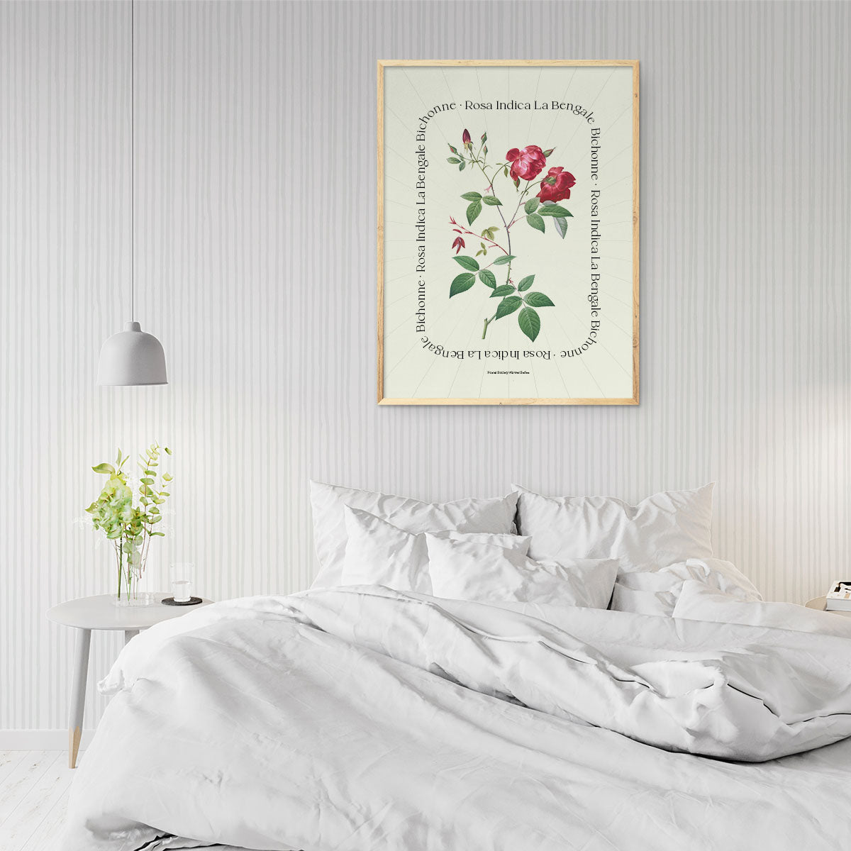 Plakat med botanisk illustration af Rosa Indica La Bengale hængende over en seng i et stilfuldt soveværelse.