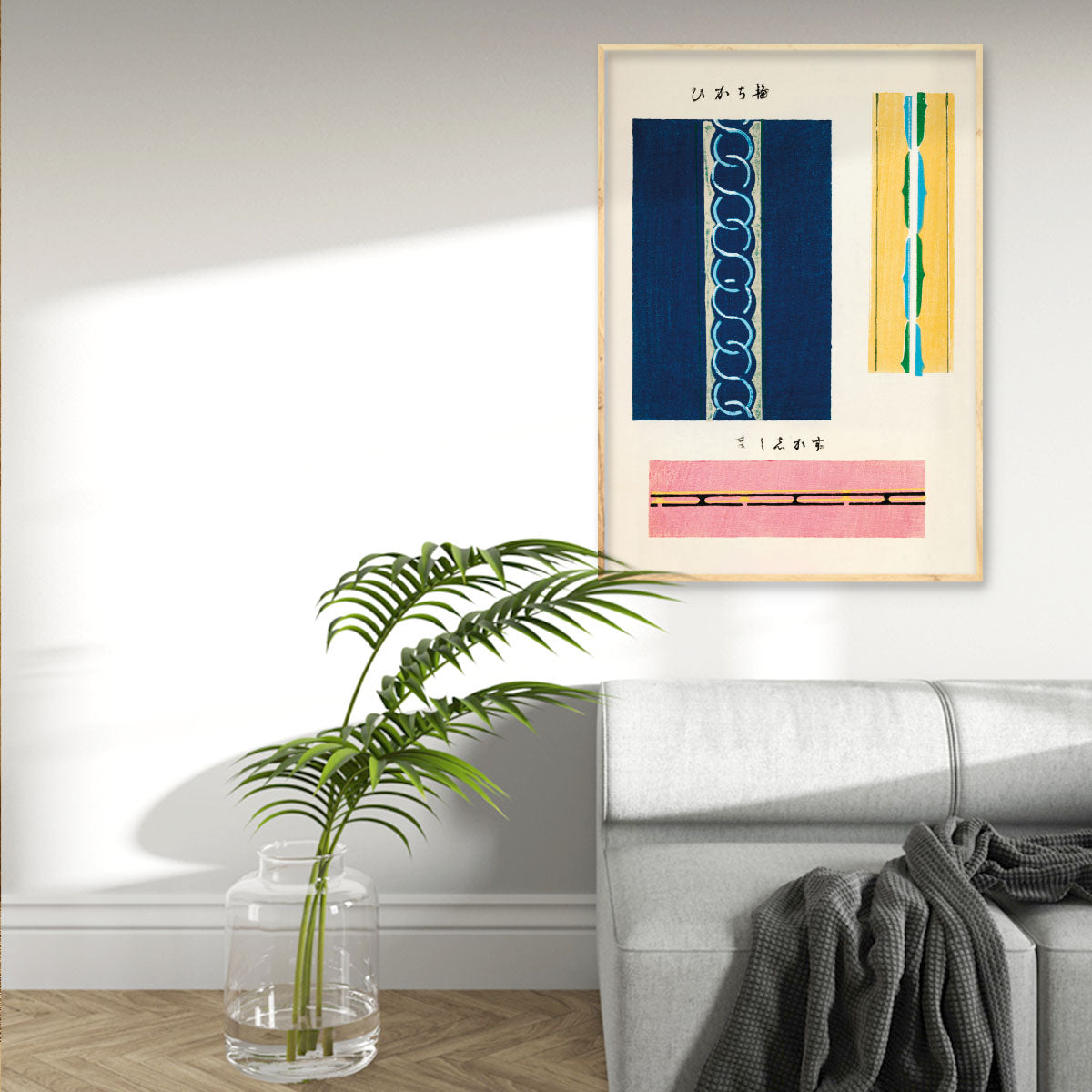 Plakat med abstrakte linjer i blå, gul og pink nuancer, hængende i en moderne stueindretning med en grå sofa og en plante i en glasvase.