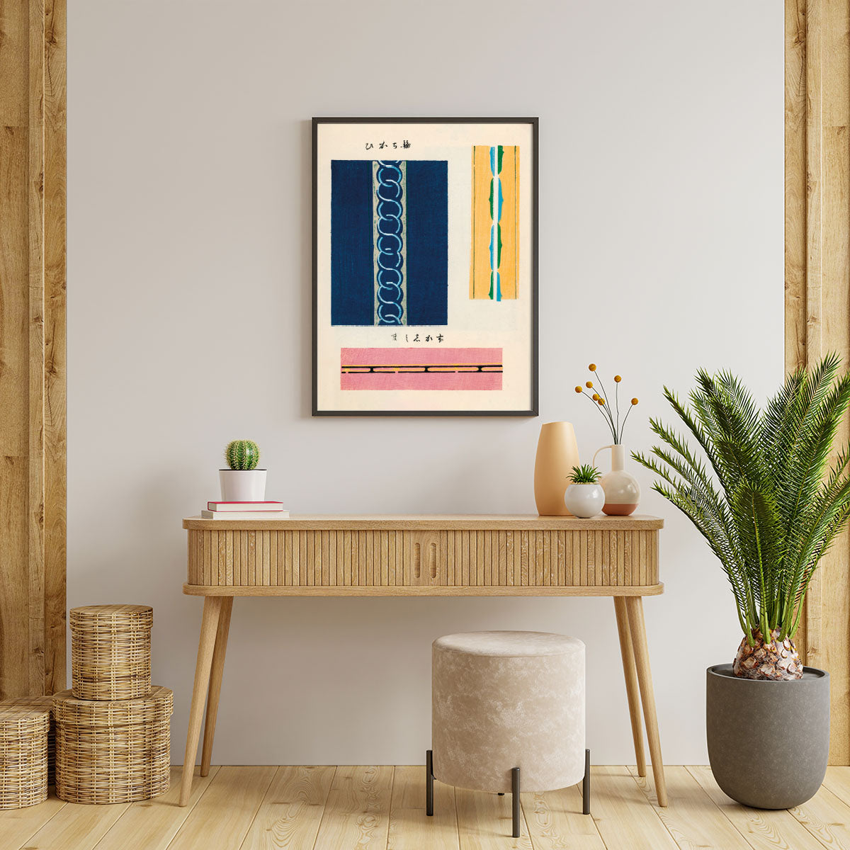 Plakat med abstrakte linjer i blå, gul og pink, hængende over et træbord med planter og dekorationer.