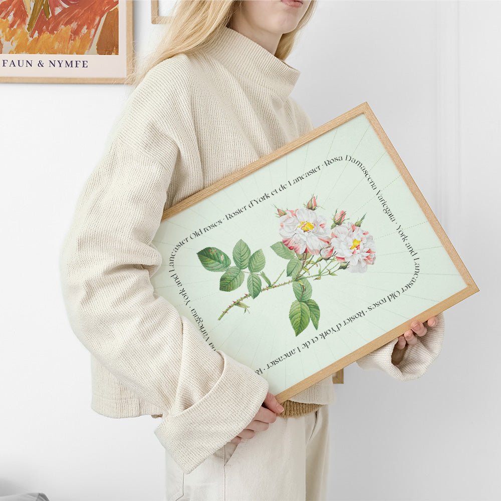 Kvinde i beige sweater holder en plakat med blomsterillustration og tekst, del af en e-handelsproduktliste.