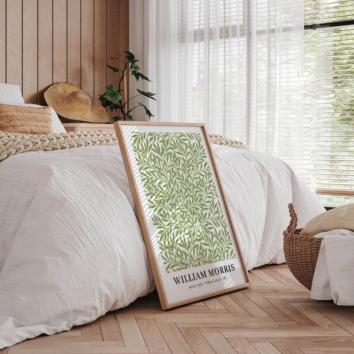 Plakat af William Morris med botanisk mønster, placeret på gulvet i et soveværelse med træpaneler og naturligt lys.