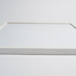 Hvid egetræsramme med minimalistisk design, set fra siden.