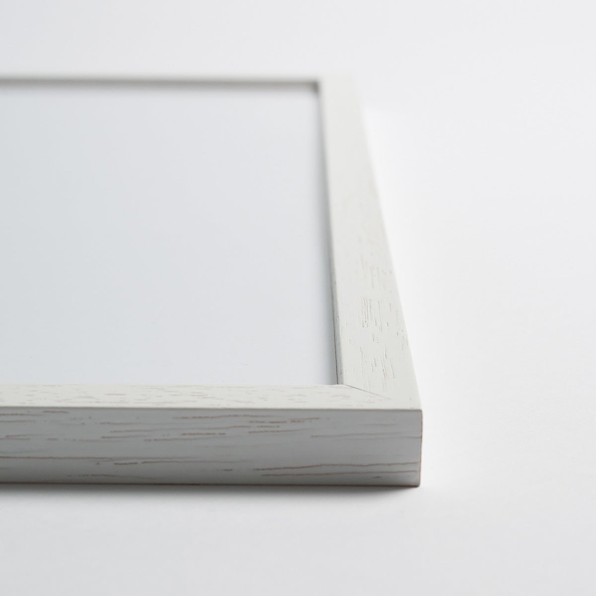 Hvid egetræsramme i nærbillede, minimalistisk design.