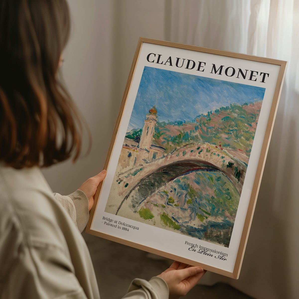 Håndholder Monet-plakat af bro, landsby og bjerge i træramme.
