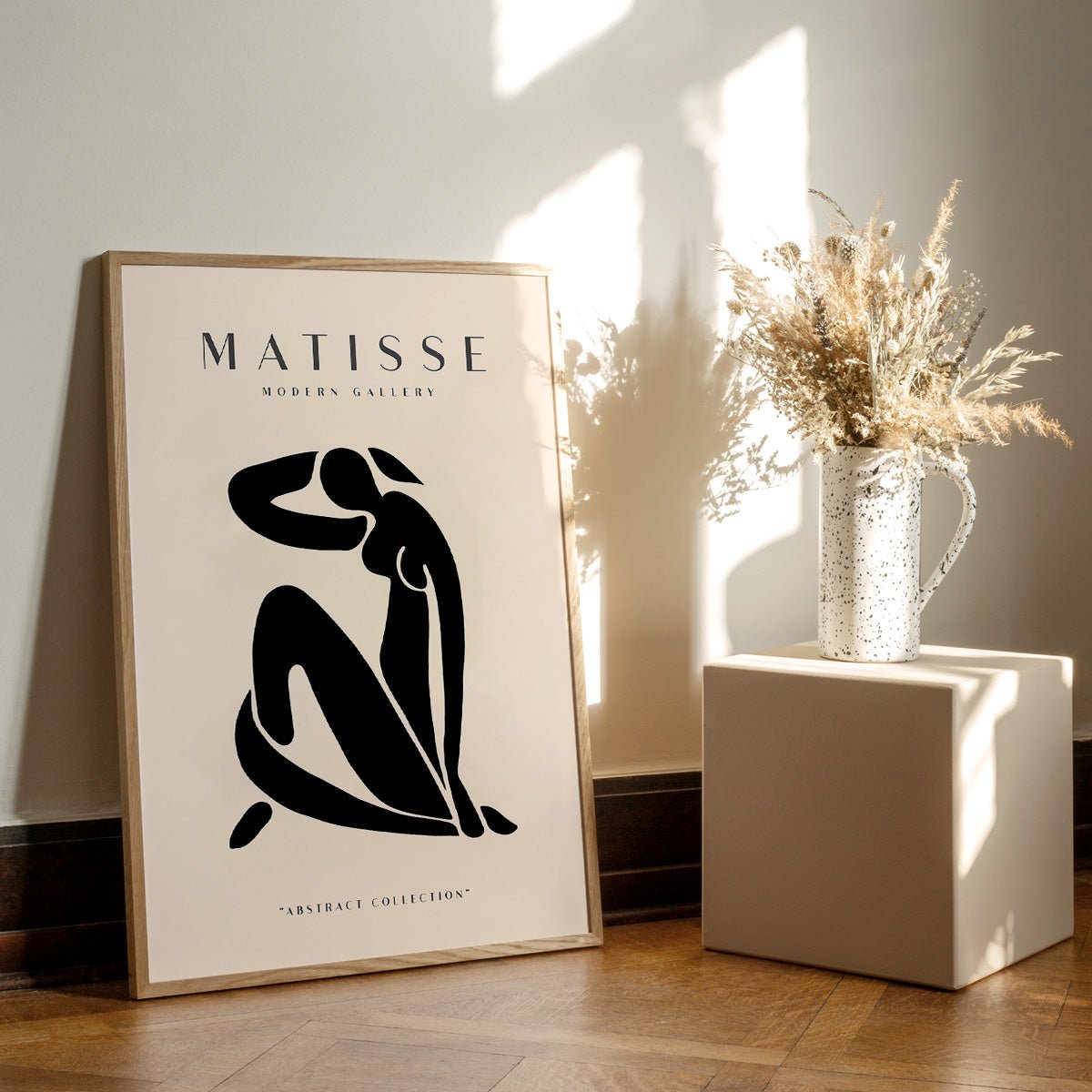 Matisse modern gallery plakat i egetræsramme på trægulv med vase og blomster.
