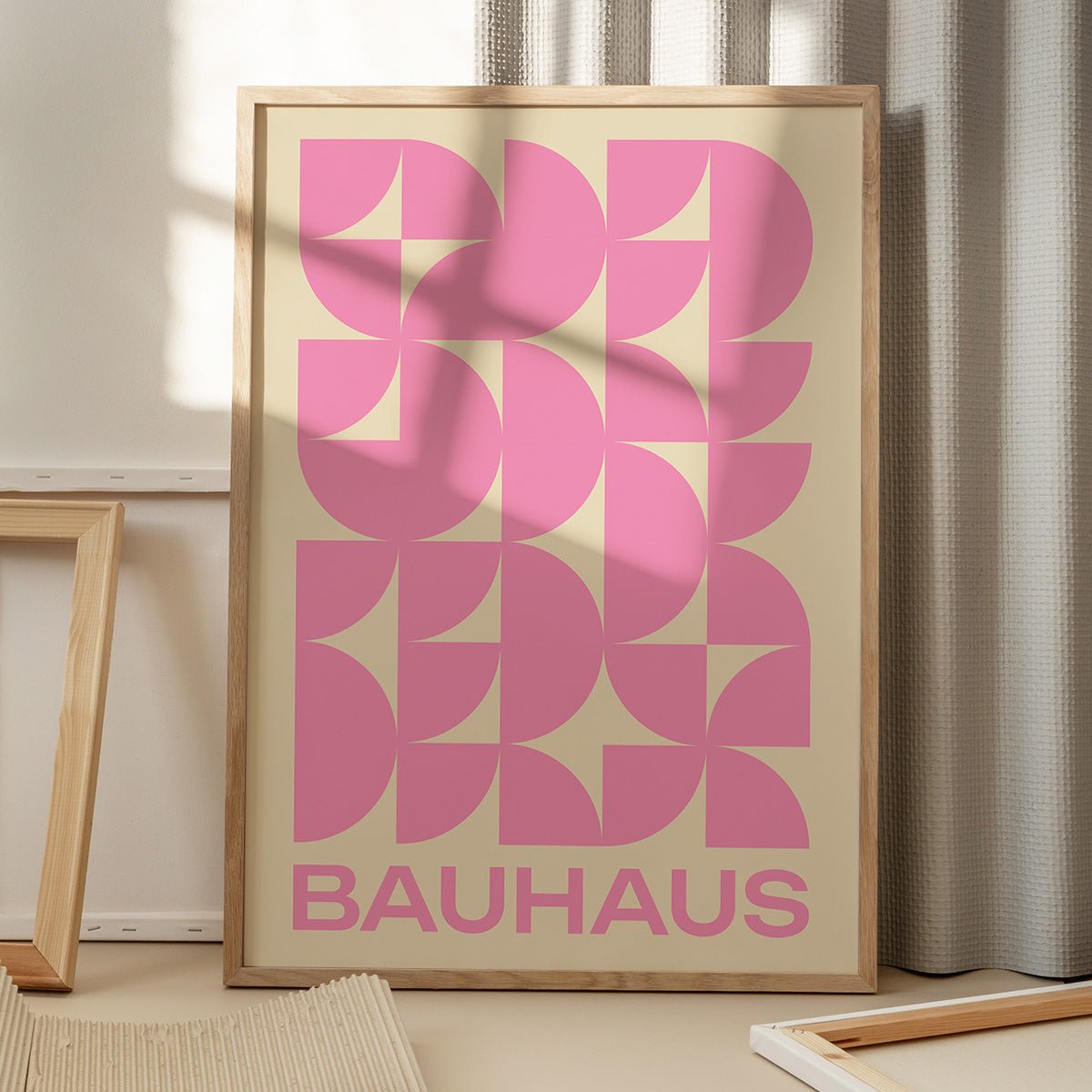 Bauhaus plakat i pink med geometriske former, placeret på gulv med skygge fra vindue, moderne kunstdesign.