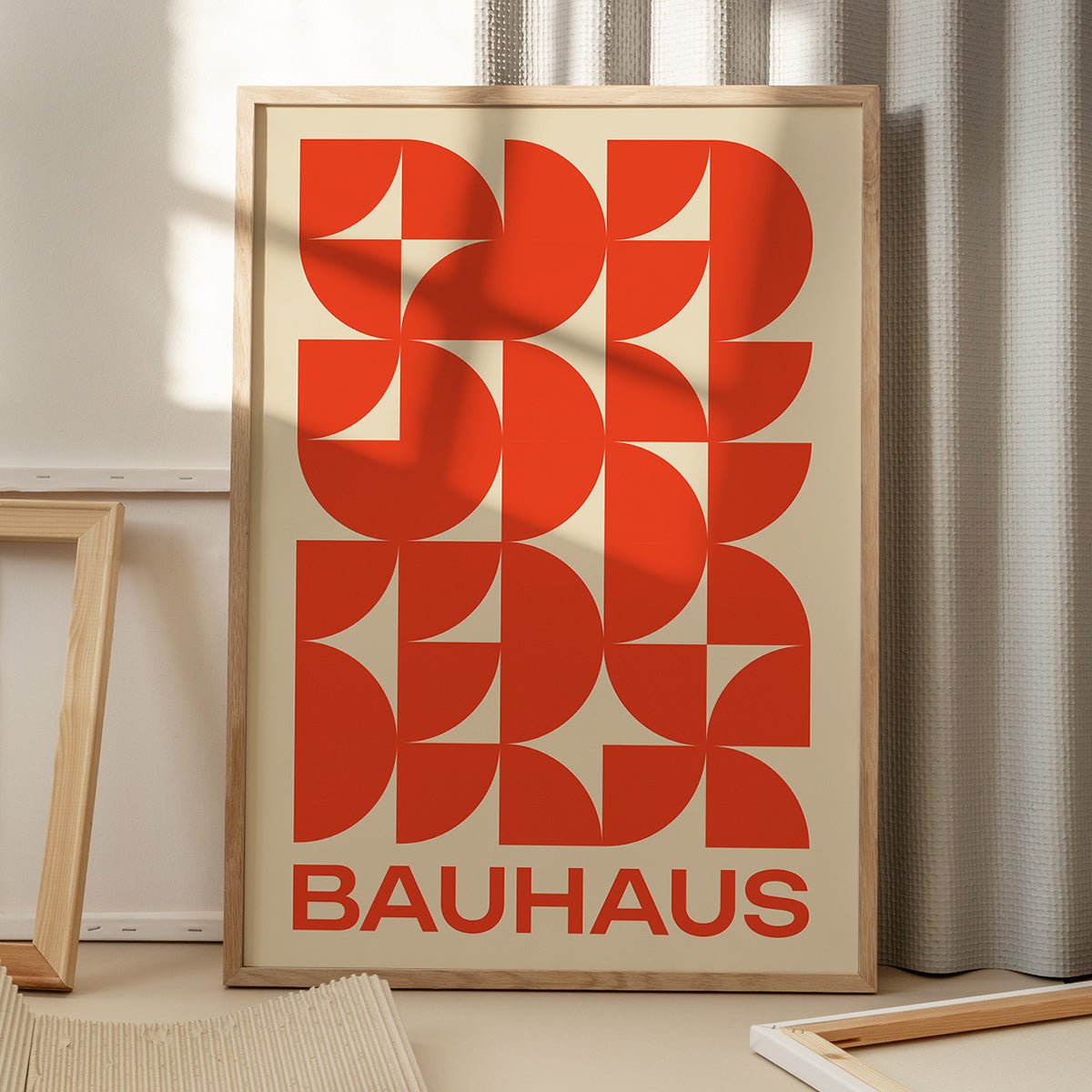 Bauhaus plakat i orange toner med geometriske former, placeret på gulv med skygger fra vindue, moderne kunstdesign.