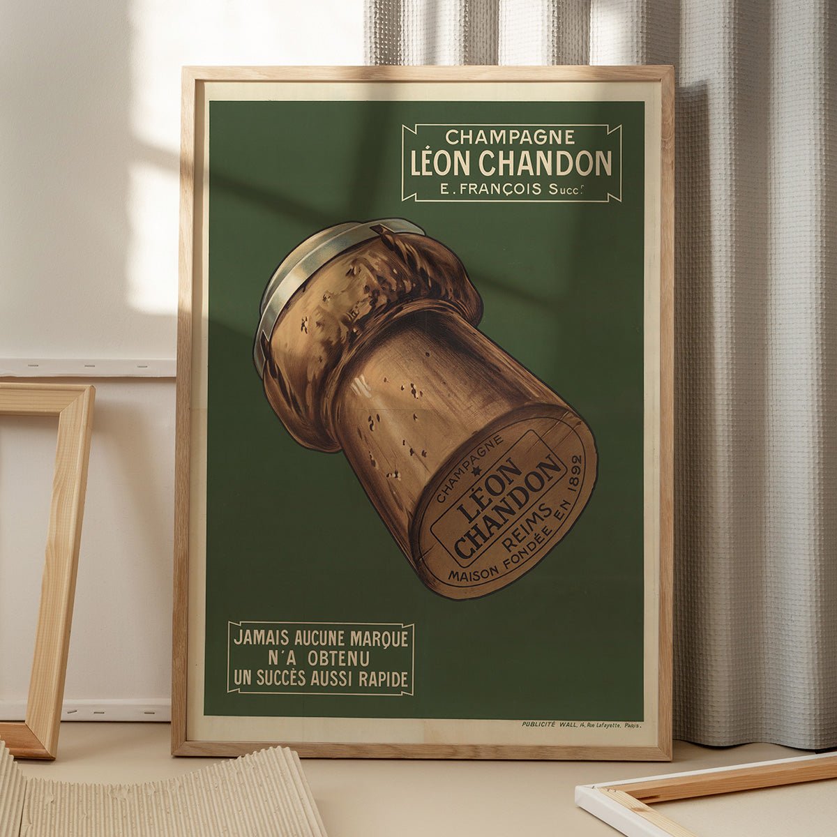 Plakat med elegant design af Champagne Léon Chandon, skygger fra vindue, placeret på gulv for stilfuld indretning.
