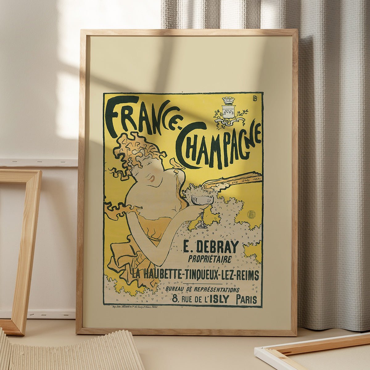 Plakat "France Champagne" med kvinde og champagneglas, i egetræsramme på gulv.