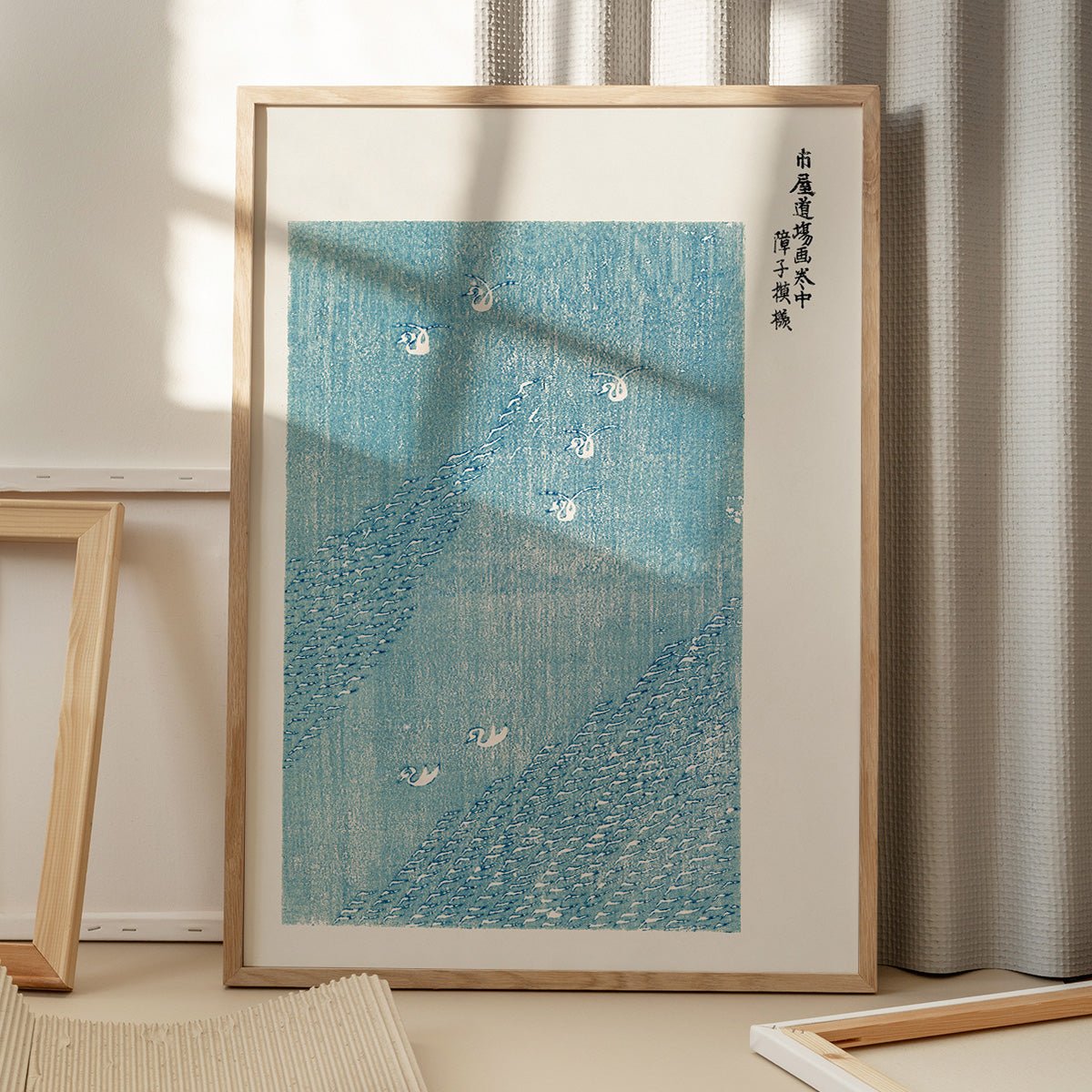 Plakat med illustration af hvide svaner i blåt vand med japansk skrift