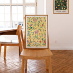 Gul plakat med blomster i træramme på stol i spisestue